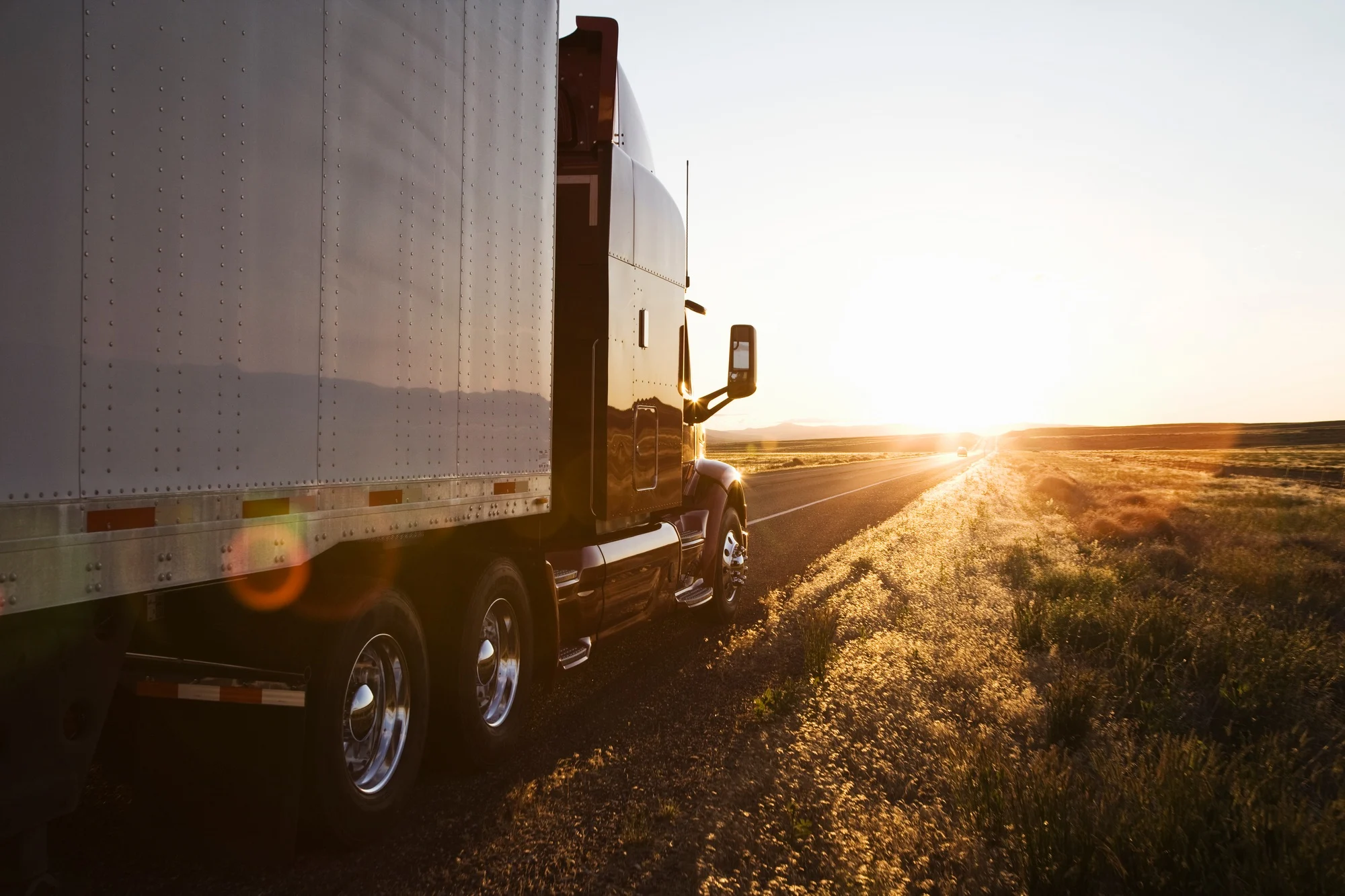 Side view of a trailer and truck on the road at sunset in eastern Washington, USA